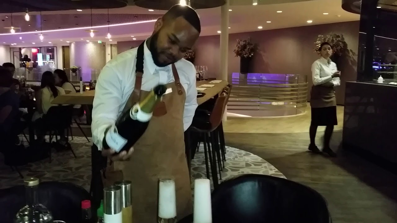 Renatus La Cruz schenkt Champagne in bij Global Dining van Holland Casino in Amsterdam West